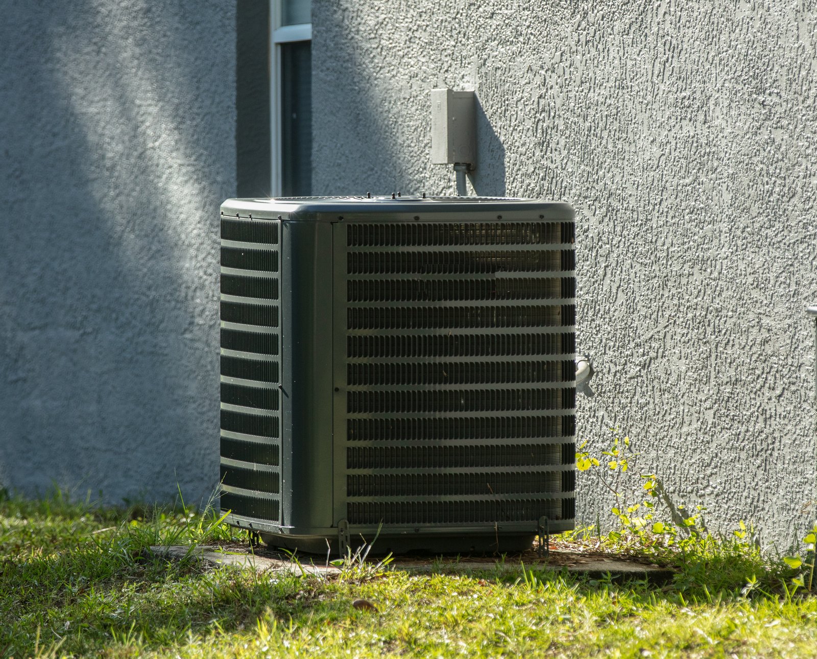 An outdoor HVAC unit installed beside a residential home, providing heating and cooling for indoor comfort.